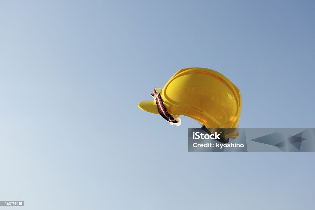 黄色工事用ヘルメットフライング中旬に air アゲインスト澄んだ空 - ヘルメット類のロイヤリティフリーストックフォト