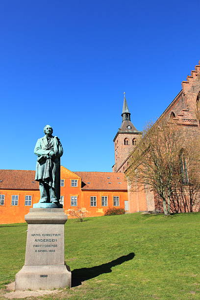 Hans Christian Andersen in his home town Odense Sculpture of World Famous Danish fairy tale writer and poet Hans Christian Andersen (1805 - 1870) in front of the Sankt Knuds kirke (church) in Odense, the town where he was born. statue of hans christian andersen stock pictures, royalty-free photos & images