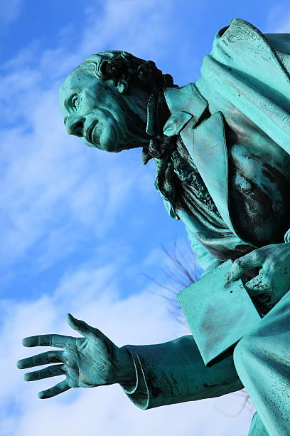 Hans Christian Andersen world famous poet in Kongens Have Sculpture of World Famous Danish fairy tale writer and poet Hans Christian Andersen (1805 - 1870) on his favourite spot in the Royal Garden (Kongens Have) Park of Copenhagen ready to read for the children. statue of hans christian andersen stock pictures, royalty-free photos & images