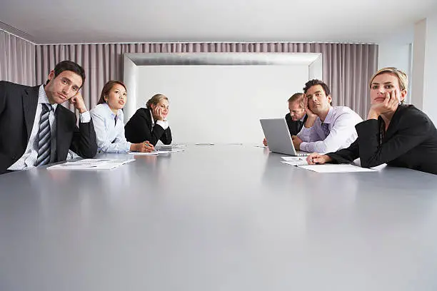 Bored multiethnic business people sitting in conference room