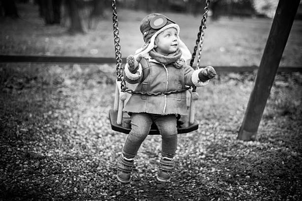 ładny mały pilot na swing - playground snow winter little girls zdjęcia i obrazy z banku zdjęć