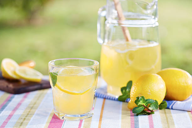 Glass of homemade lemonade Glass of homemade lemonade in a garden table lemonade stock pictures, royalty-free photos & images