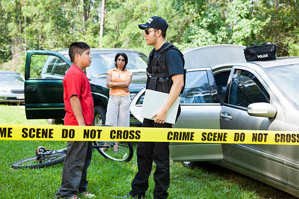 Policeman questions witnesses during vehicle accident.