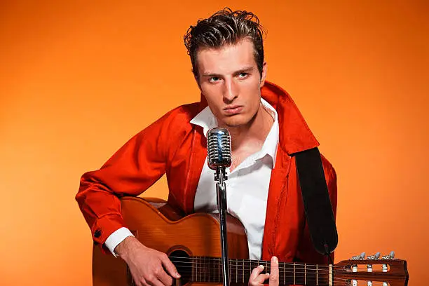 Photo of Retro fifties rock and roll singer playing accoustic guitar.