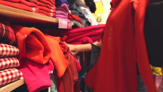 HD:Woman selecting items in a clothes shop.