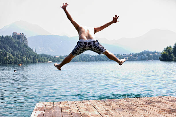 istock Man in mid air jumping into lake 463215501
