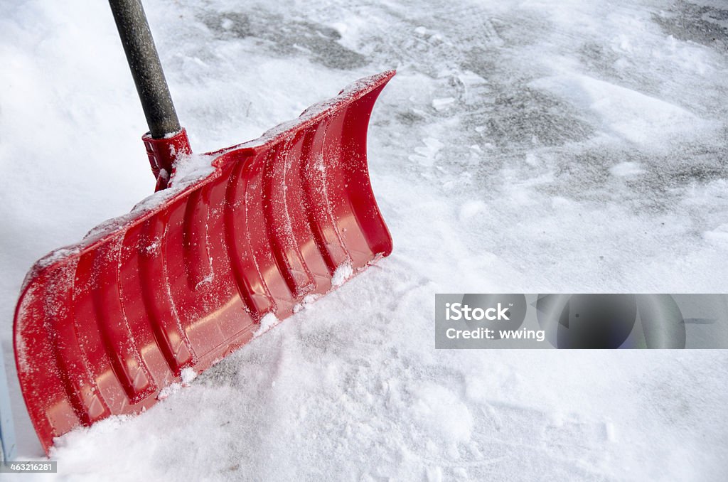 Red Snow Shovel A red snow shovel with snow ... very close-up with copy space Snow Shovel Stock Photo