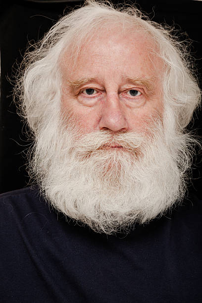 intense senior white bearded man on dark background intense senior white bearded man on dark background  - against plain dark background bushy stock pictures, royalty-free photos & images