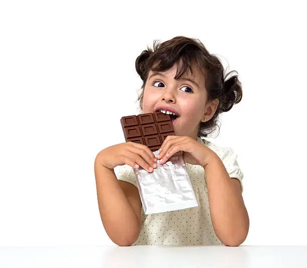 Photo of Young girl eating large chocolate bar