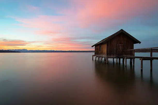 Traditional boathouse at lake Ammersee at sunrise.