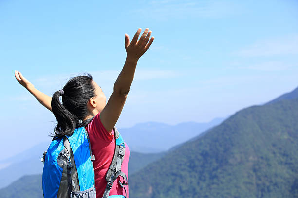 istock happy hiking woman open arms at mountain peak 463234921
