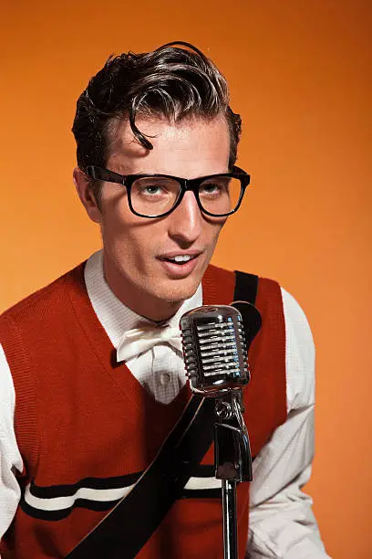 Photo of Retro fifties style rock and roll singer with vintage microphone.