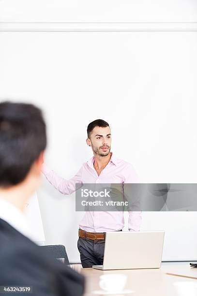 Confident Business Man Standing By A Table With Laptop Stock Photo - Download Image Now
