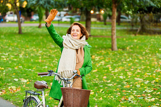 istock Senior Woman Waving With Bicycle 463244597