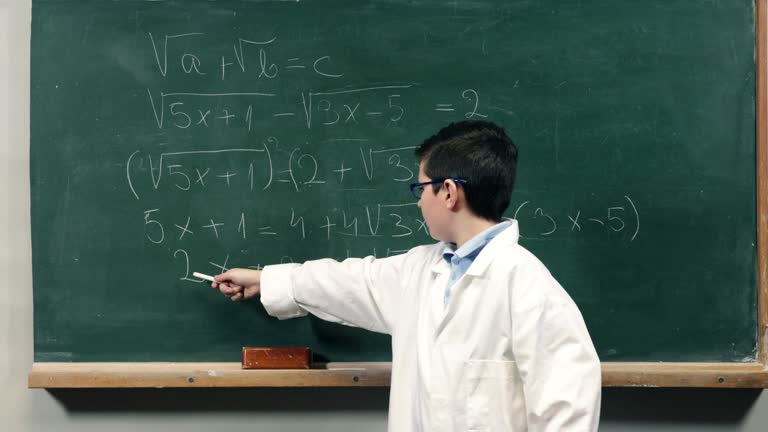 Child explaining a mathematical equation on blackboard