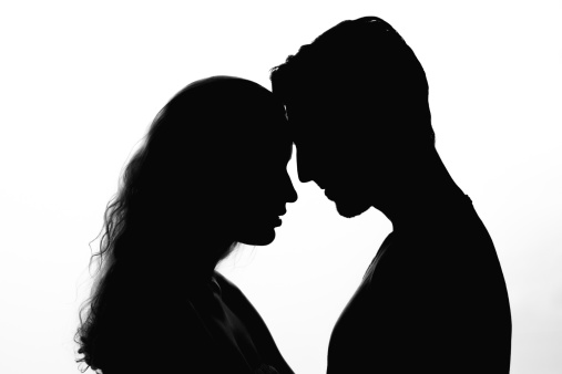 Silhouette of affectionate couple face to face on white background