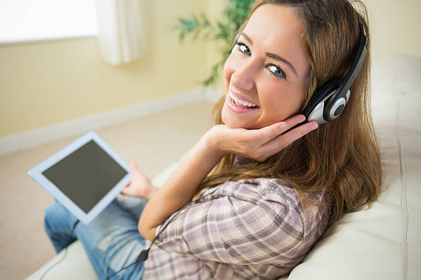 istock Beautiful woman sitting on sofa and smiling at camera 463268057