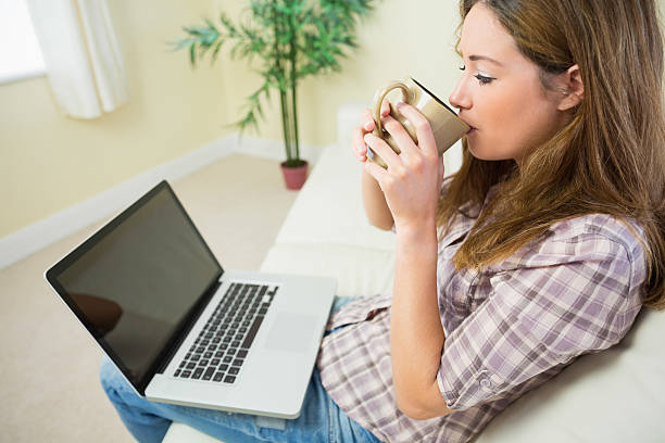 istock Woman sitting on a couch and drinking coffee 463268151