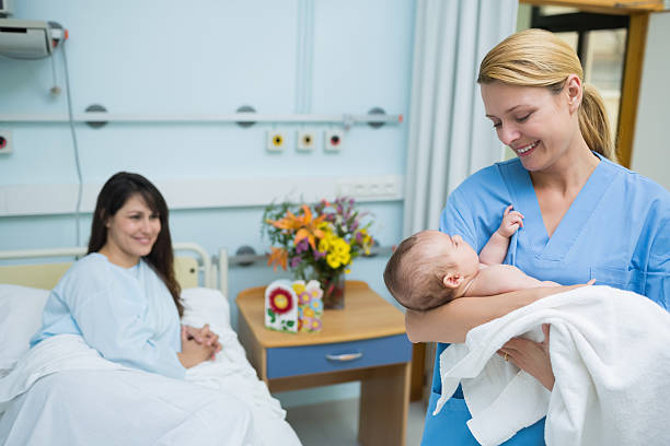 istock Smiling nurse holding a new born baby 463270617