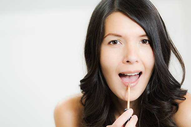 istock Beautiful woman applying lip gloss 463271909