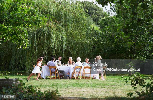 Happy Family Dining Together In Garden Stock Photo - Download Image Now - Dining, Family, Grandparent