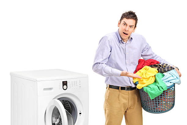 istock Man holding a laundry basket and gesturing near washing machine 463276693