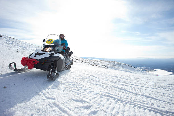 menschen auf dem schneemobil im winter berge - schneemobilfahren stock-fotos und bilder