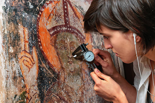 Girl measuring for renovation an ancient fresco. Caucasic girl with brown hair taking checking  fresco photos stock pictures, royalty-free photos & images