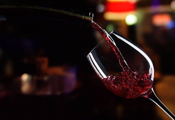 Red wine being poured from a bottle into a wine glass