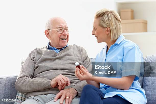 Nurse Explaining The Medication To Senior Man In Care Home Stock Photo - Download Image Now