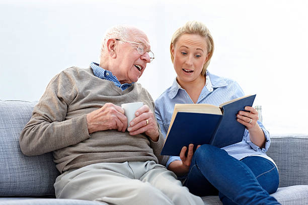 老人男性、女性の読書 carer 一緒に - grandparent senior adult child reading ストックフォトと画像