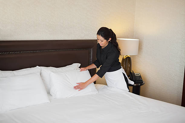 istock Cute maid tidying the bed 463313077