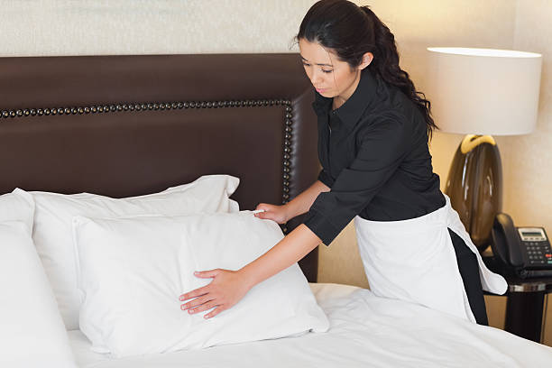 istock Calm hotel maid fixing pillows 463313261