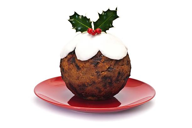 Christmas pudding on red plate with mistletoe decoration Traditional Round Christmas Pudding christmas pudding stock pictures, royalty-free photos & images