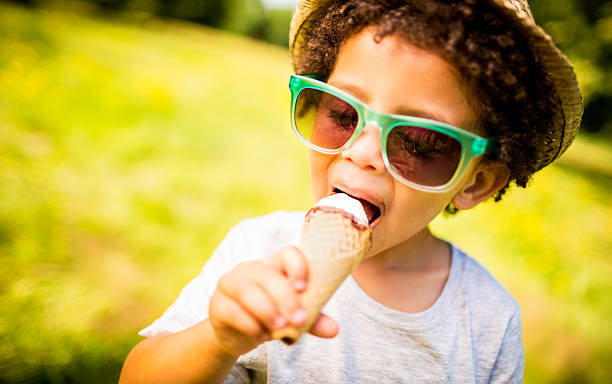 kleine junge anstrengenden lecken-eis in einem kegel - child chocolate ice cream human mouth stock-fotos und bilder