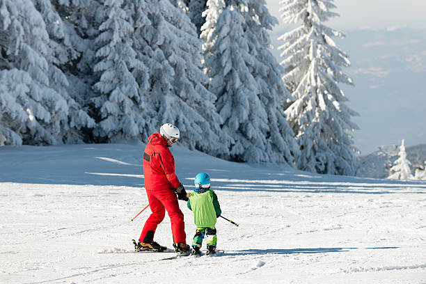 Skiing instructor and child on ski slope Skiing instructor and child on ski slope ski instructor stock pictures, royalty-free photos & images