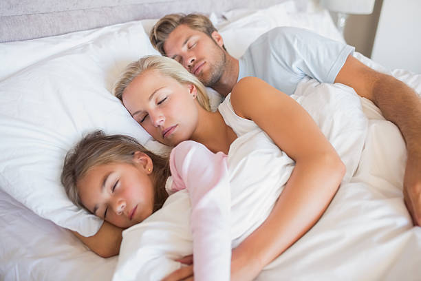 istock Parents in bed with their daughter 463316391