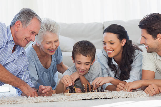 istock Happy family playing chess lying on a carpet 463318537