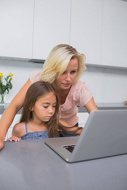 istock Mother and daughter using a laptop 463319555
