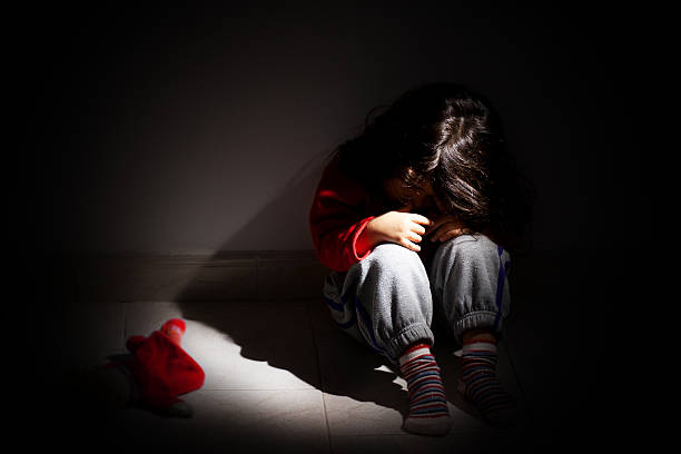 Childhood problems - Child abuse young girl sitting down alone in the dark. baby girls stock pictures, royalty-free photos & images