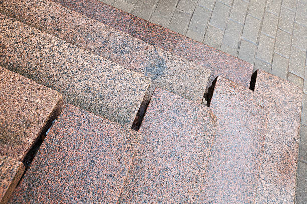 istock Old stairs made of red granite on gray pavement 463326199