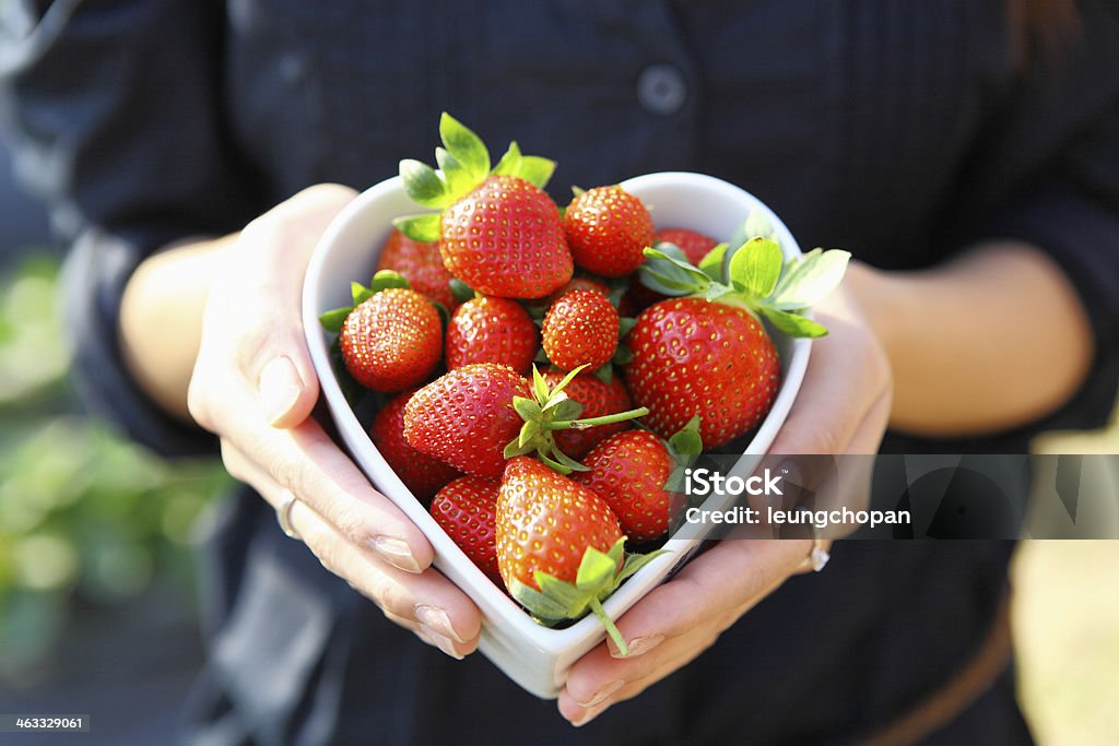 strawberry in heart shape bowl with hand Abundance Stock Photo