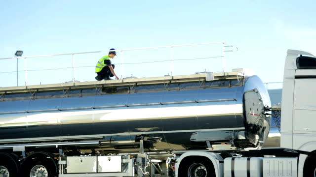 Worker checking tank on truck