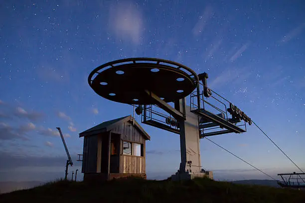 A lonesome ski lift and building under a summer starry sky at Mt Buller in the Victorian High Country, Australia