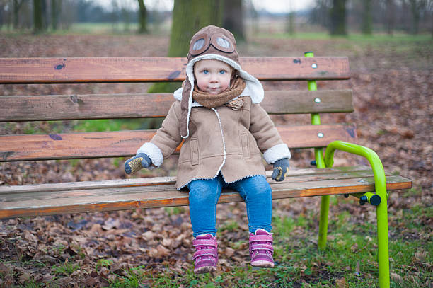 ładny mały pilot siedzi na ławce - playground snow winter little girls zdjęcia i obrazy z banku zdjęć