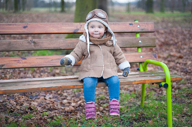 ładny pilot siedzi na ławce - playground snow winter little girls zdjęcia i obrazy z banku zdjęć