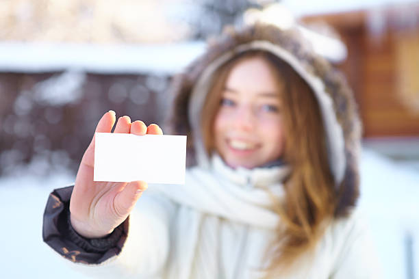 istock Young beautiful girl with blank visiting card. Winter. 463360849