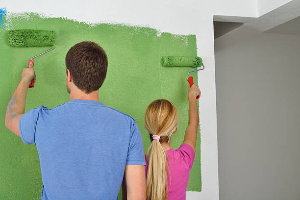 istock happy couple paint wall at new home 463364767