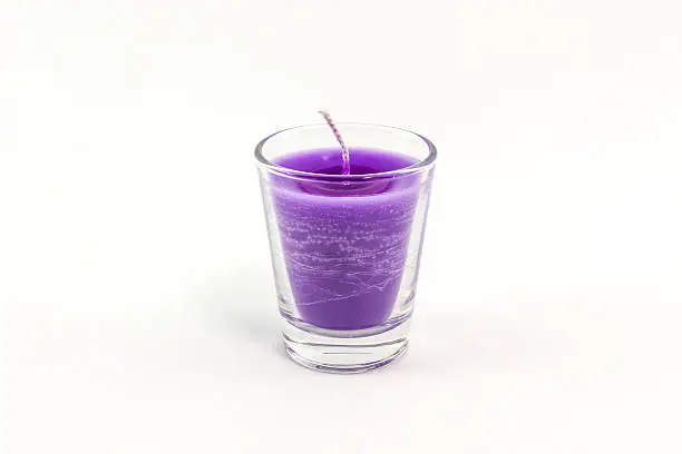 Beautiful colorful candle in glass isolated on white background.