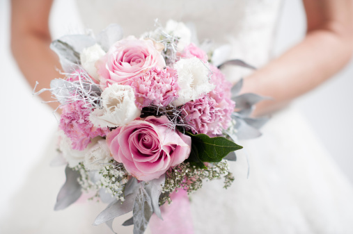 Bride holding flower bouquet.